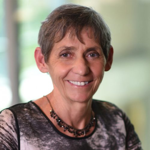 Headshot of Dean Janeen Hill of Crean College, smiling warmly in a natural setting.